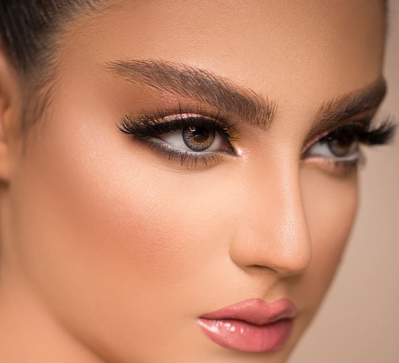 Detalhe dos olhos de uma modelo, com cílios alongados e maquiagem.